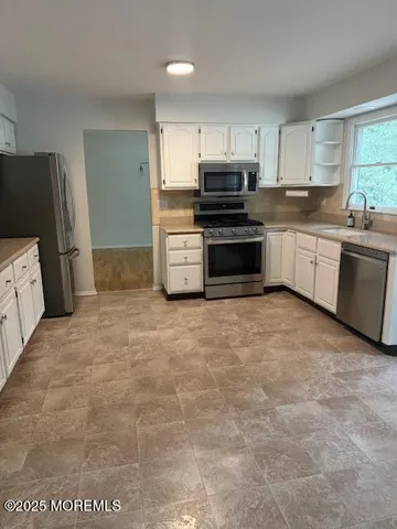 a kitchen with stainless steel appliances a refrigerator sink and stove