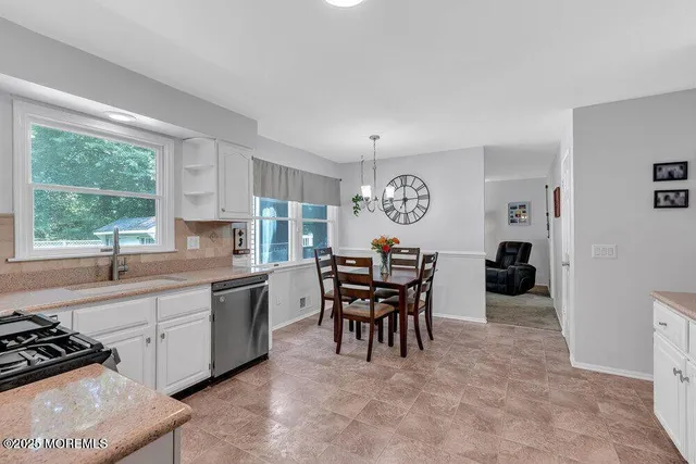 a large white kitchen with a window and stainless steel appliances