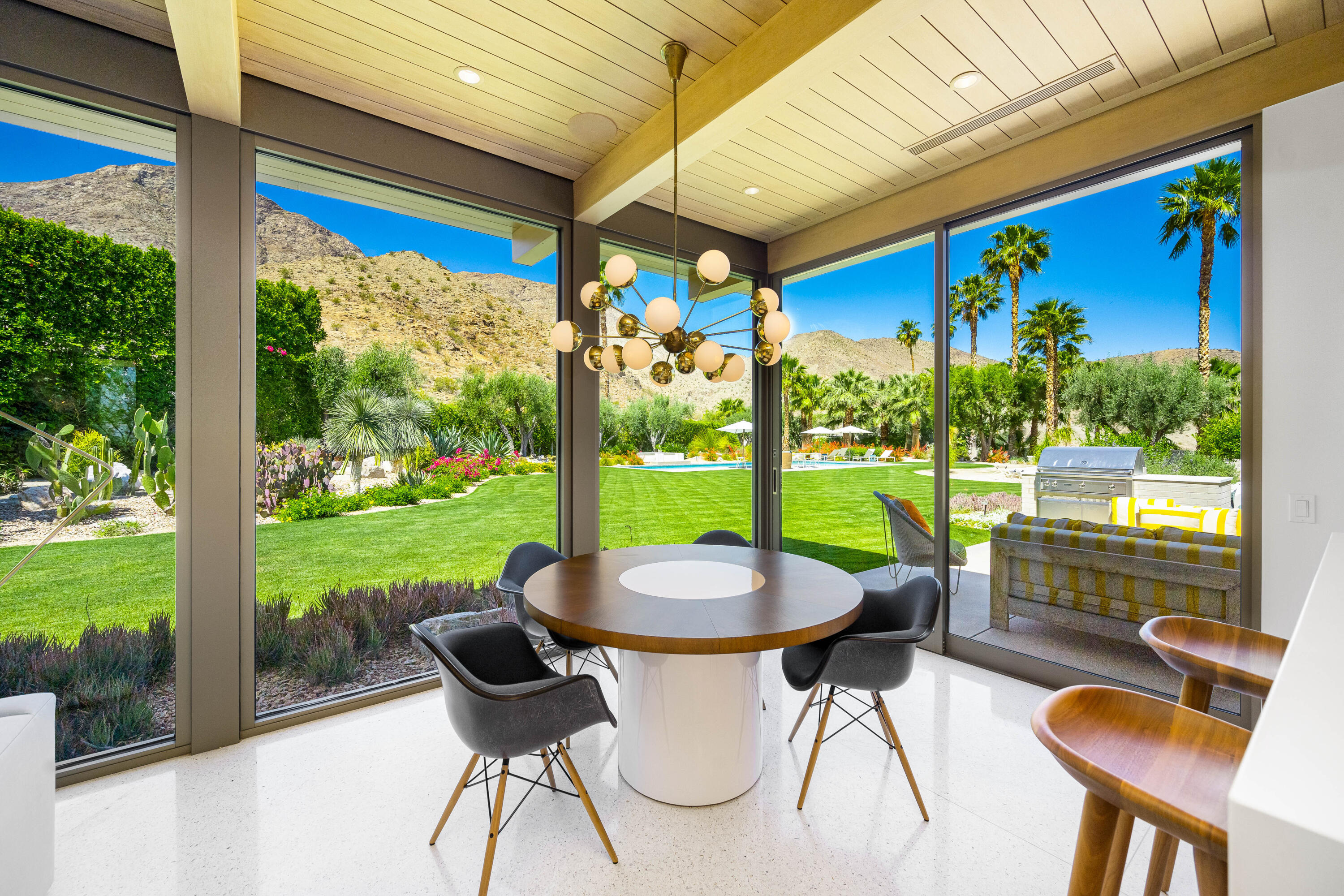70155 Carson Road Rancho Mirage, CA 92270 - Photo 28 of 56 a view of a patio with table and chairs potted plants with wooden floor and fence
