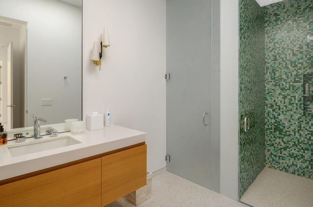 a bathroom with a double vanity sink a toilet and shower