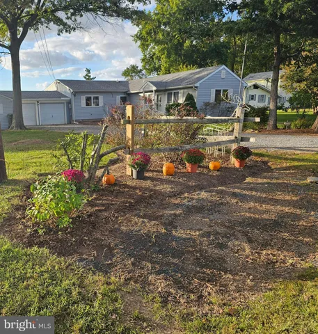 a view of a house with a big yard and large trees
