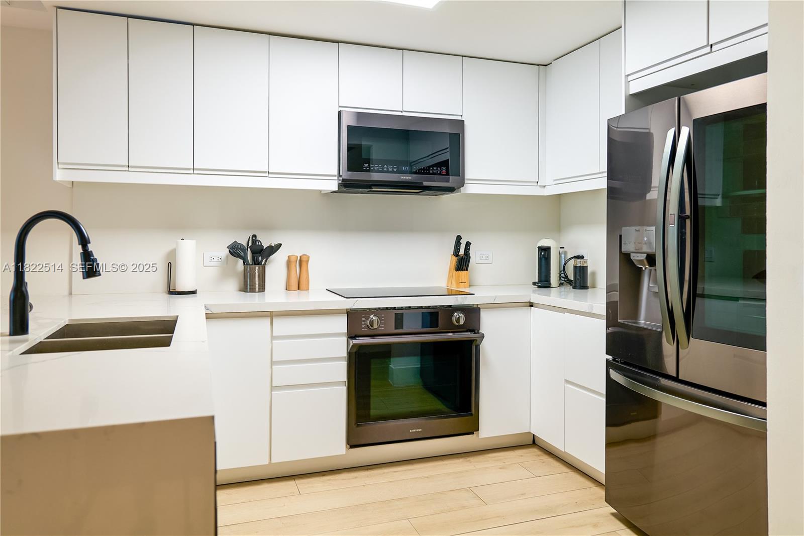 2301 Collins Avenue, Unit 329 Miami Beach, FL 33139 - Photo 8 of 47 a kitchen with stainless steel appliances granite countertop a refrigerator stove and sink