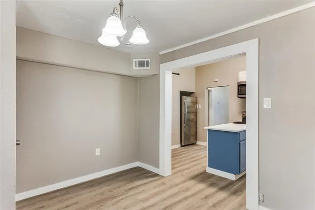 a view of a hallway with wooden floor and a cabinet