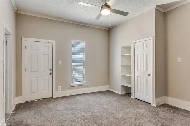 an empty room with windows and ceiling fan