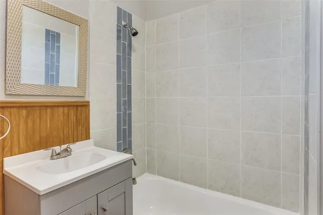 a bathroom with a sink shower and a mirror