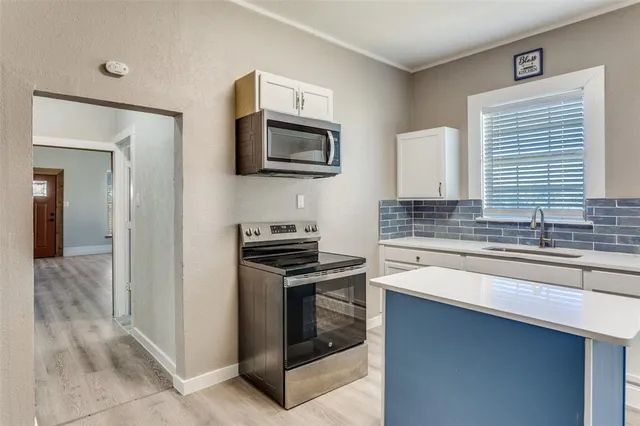 a kitchen with stainless steel appliances a sink stove and microwave
