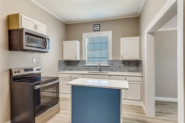 a kitchen with stainless steel appliances granite countertop a stove and a microwave