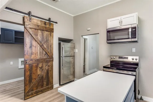 a hallway with a stove and a microwave