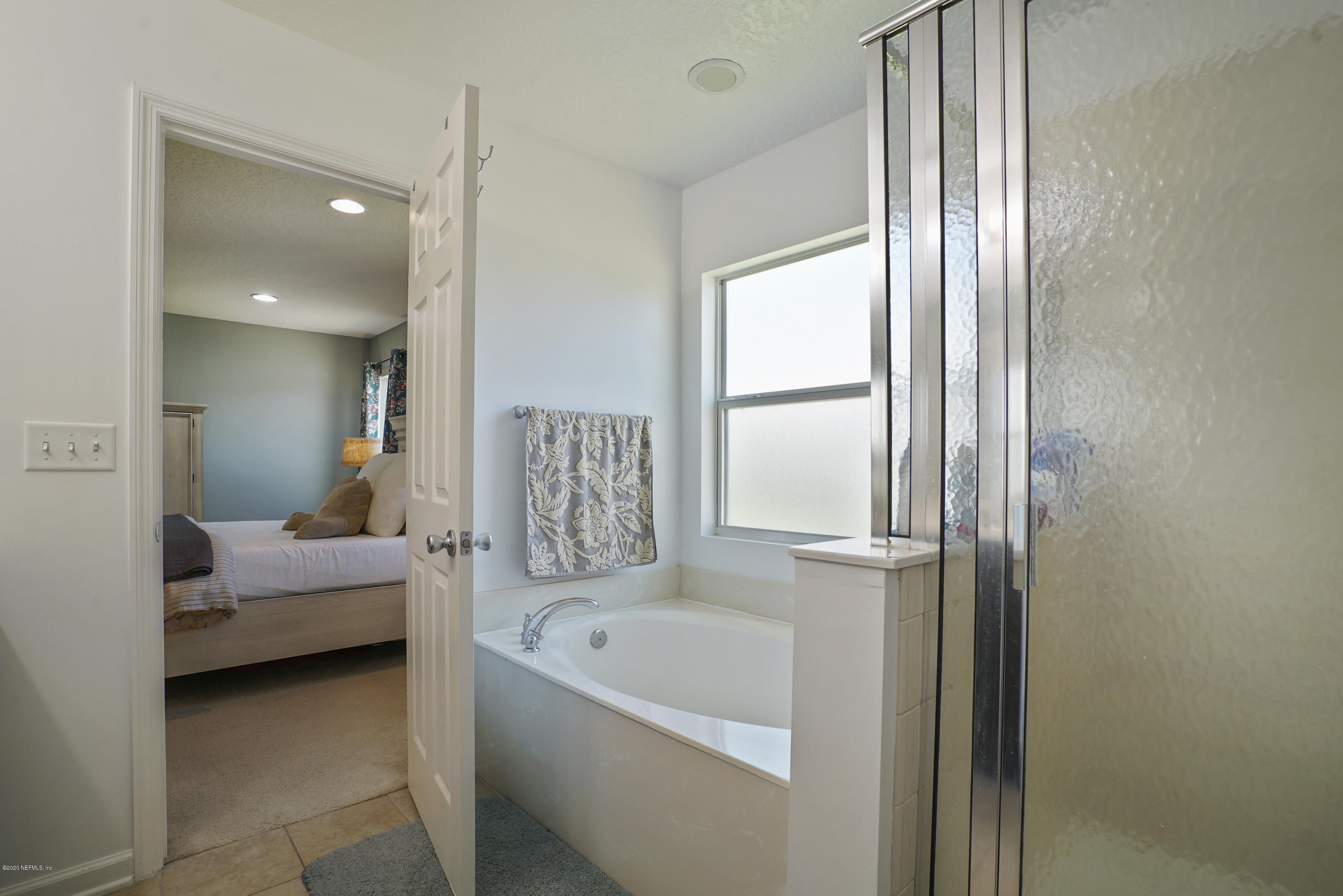4447 Oak Moss Loop Middleburg, FL 32068 - Photo 20 of 36 a bathroom with a tub sink and mirror