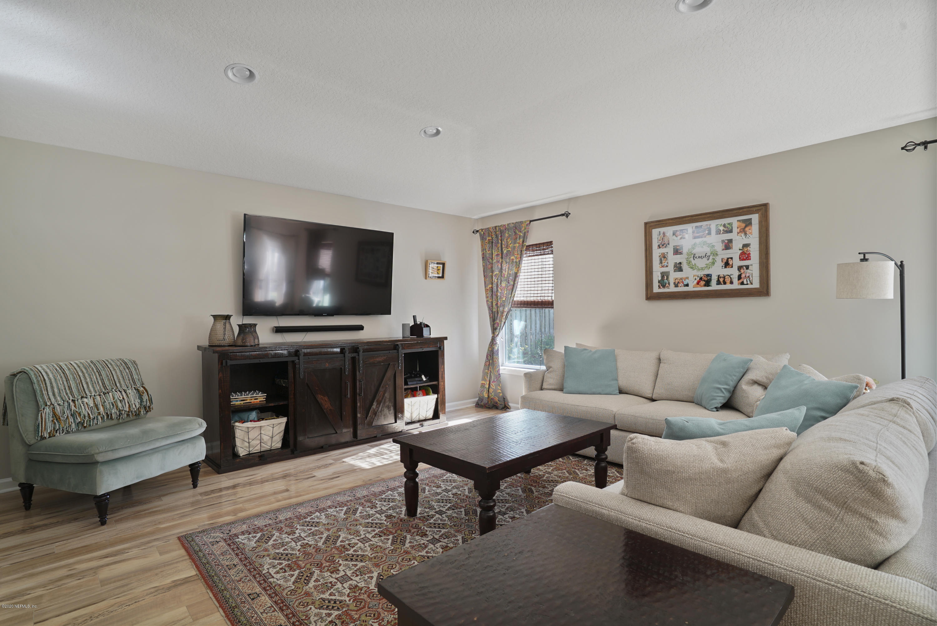 4447 Oak Moss Loop Middleburg, FL 32068 - Photo 2 of 36 a living room with furniture and a flat screen tv
