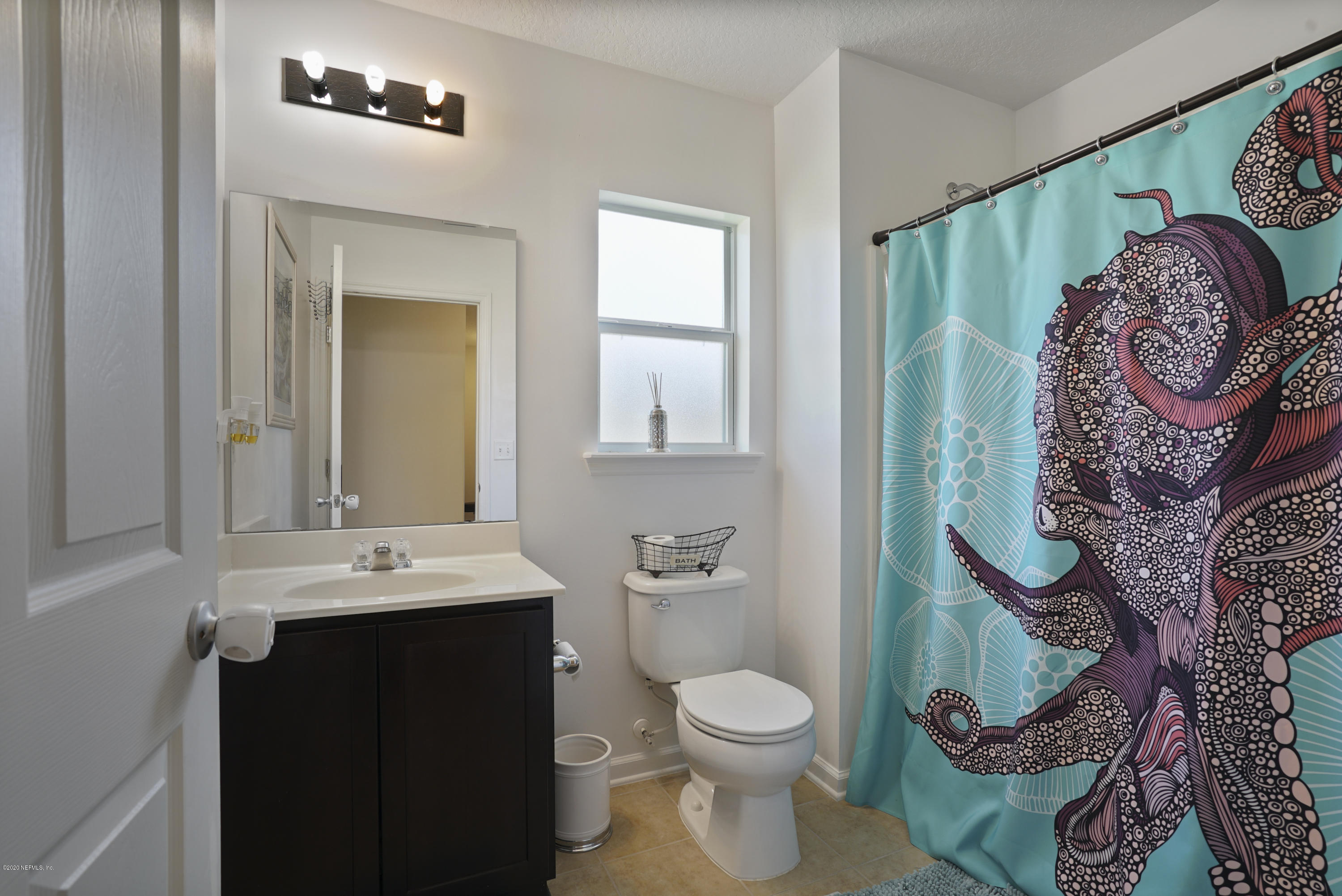 4447 Oak Moss Loop Middleburg, FL 32068 - Photo 25 of 36 a bathroom with a toilet a sink and mirror
