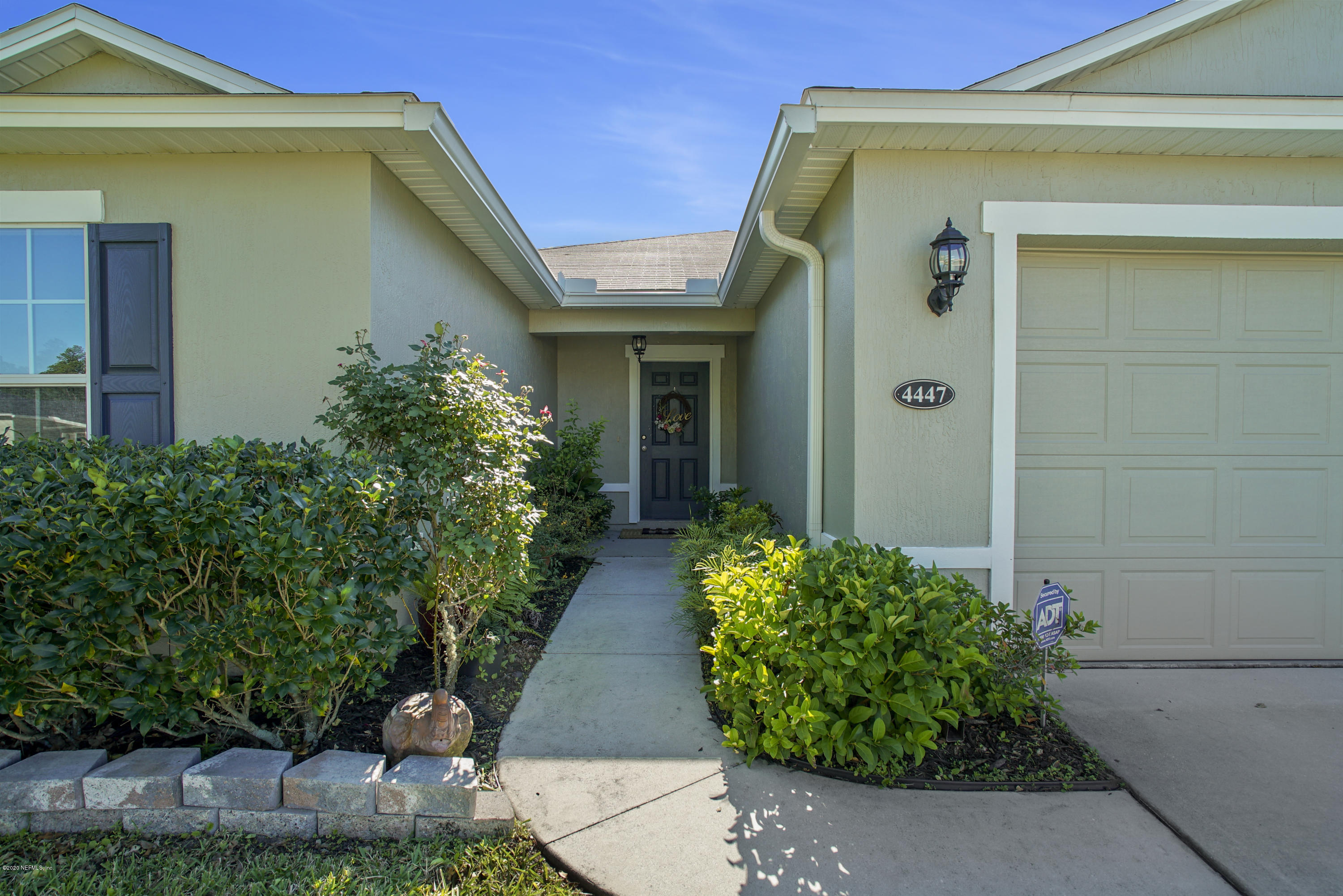 4447 Oak Moss Loop Middleburg, FL 32068 - Photo 33 of 36 a front view of a house with garden