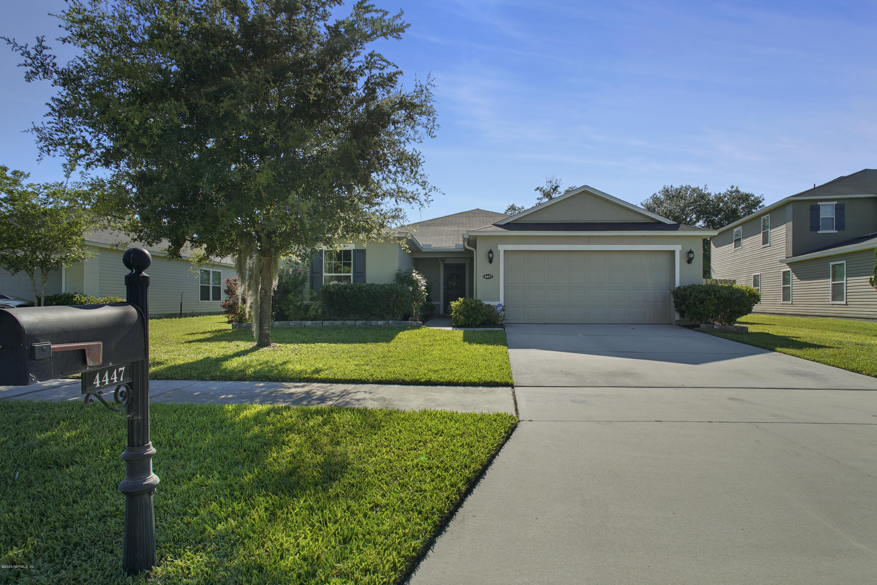 4447 Oak Moss Loop Middleburg, FL 32068 - Photo 34 of 36 a view of a house with a big yard potted plants and a large tree