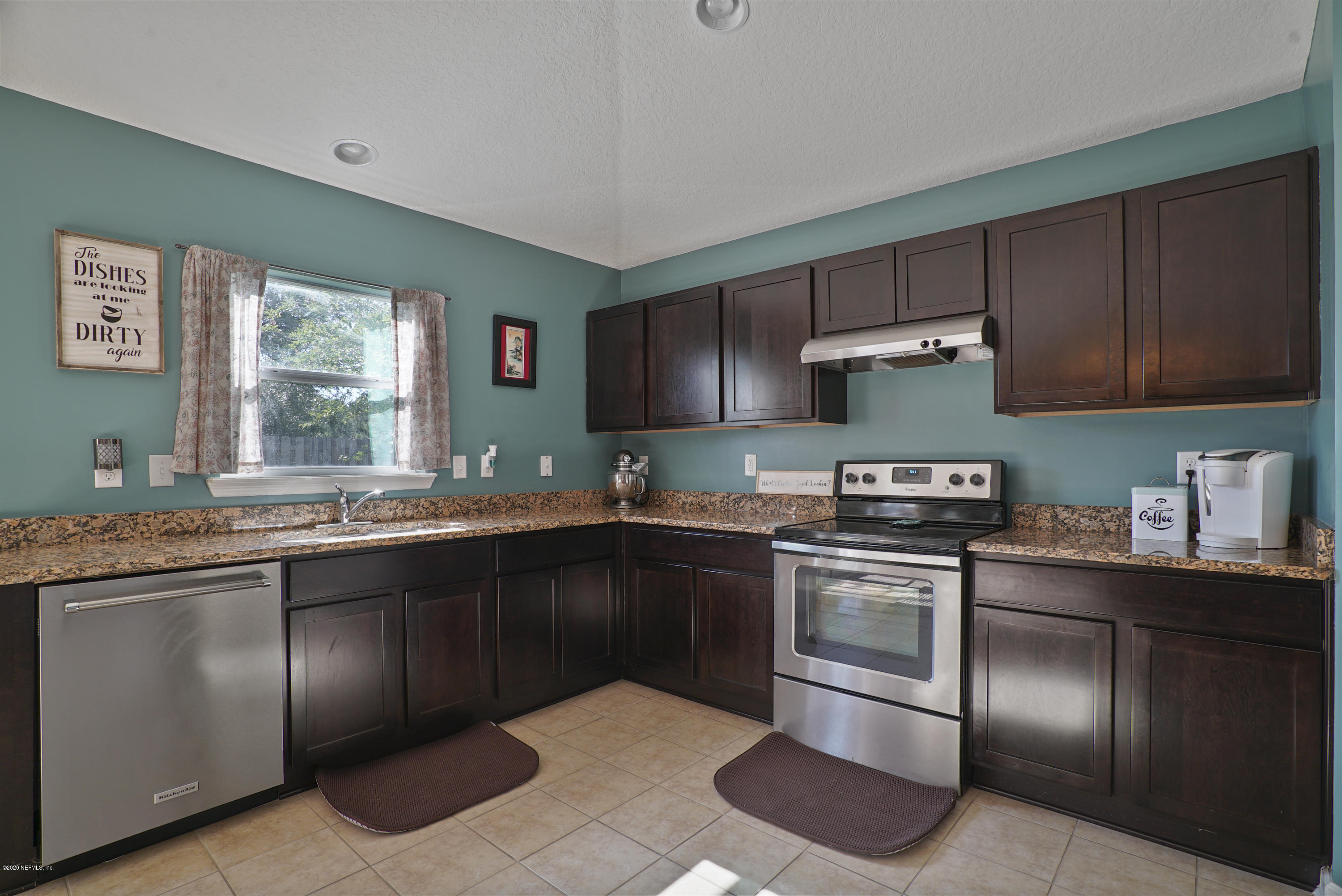 4447 Oak Moss Loop Middleburg, FL 32068 - Photo 6 of 36 a kitchen with stainless steel appliances granite countertop a sink stove and refrigerator