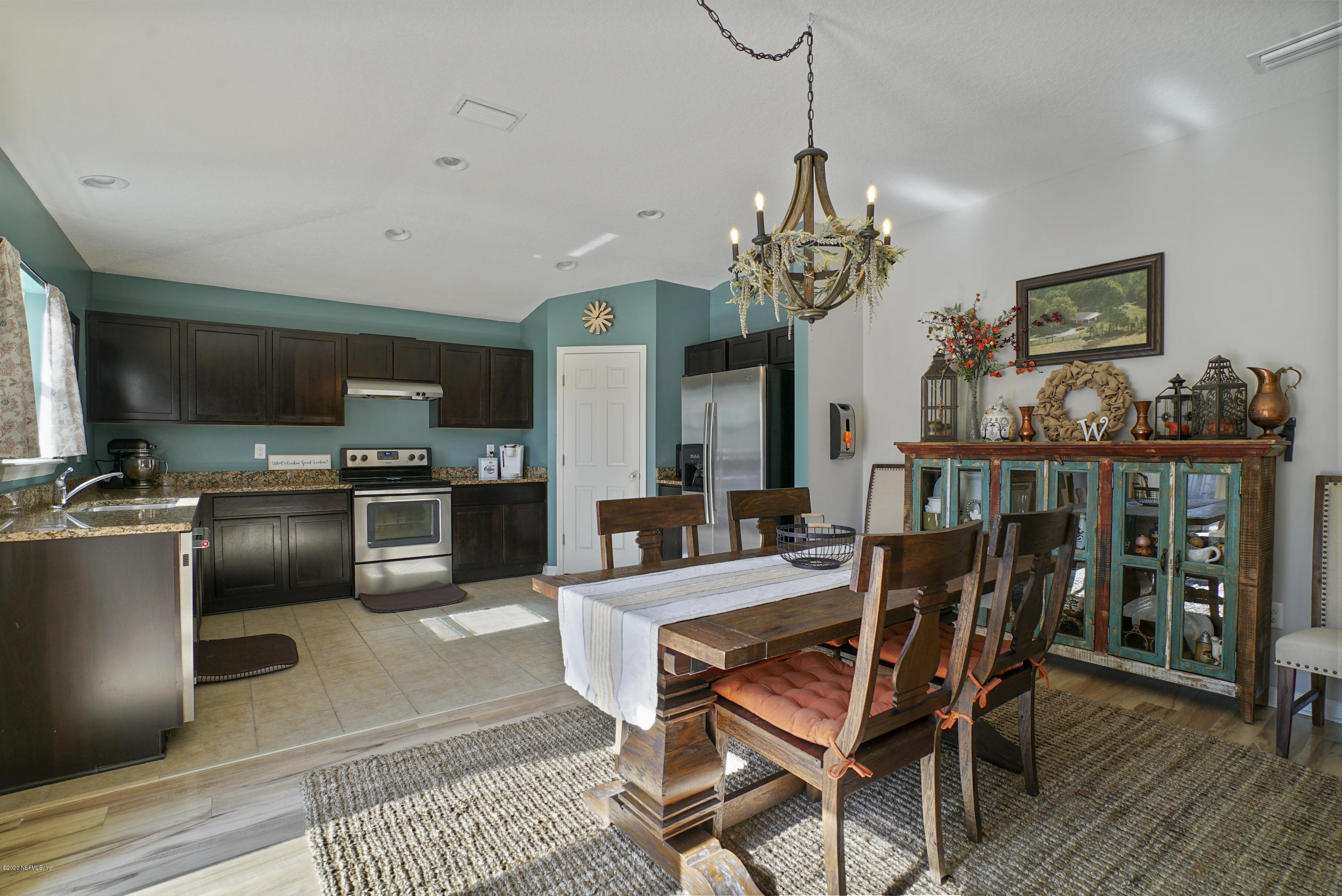 4447 Oak Moss Loop Middleburg, FL 32068 - Photo 9 of 36 a dining room with furniture a chandelier and wooden floor
