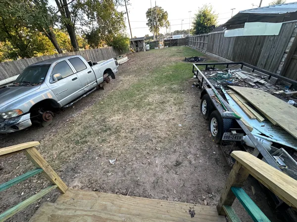 a view of a backyard with a car parked on the road