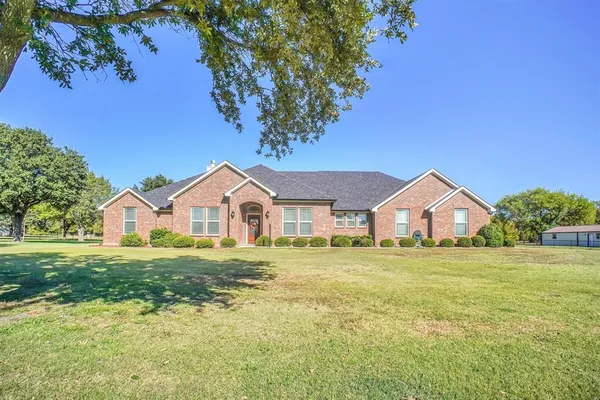 a front view of a house with a yard and trees