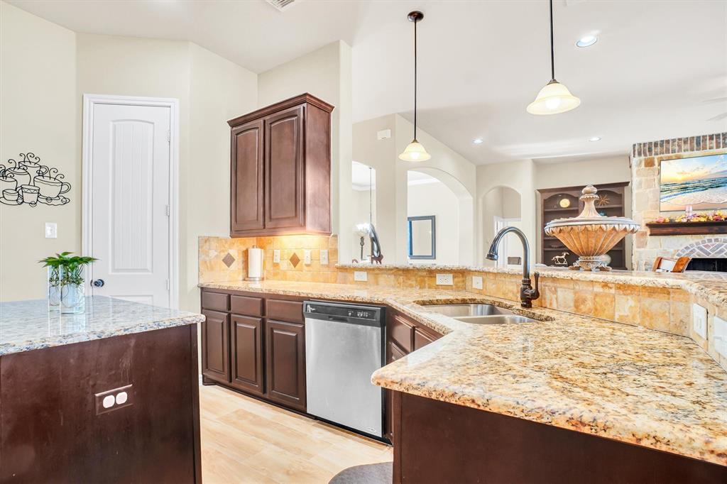 14095 Pecan Lane Forney, TX 75126 - Photo 11 of 40 a kitchen with kitchen island granite countertop a sink stove and wooden cabinets