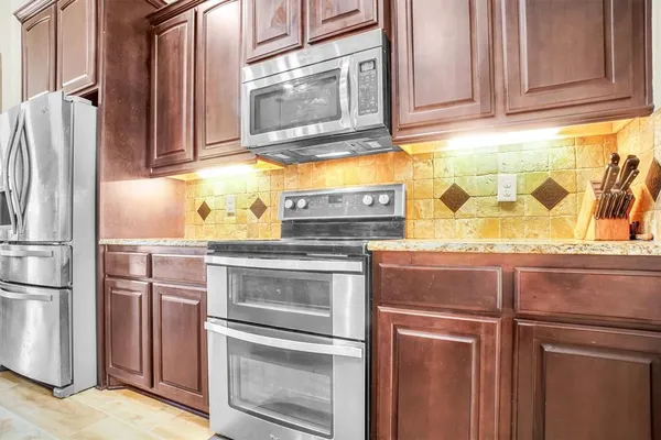 a kitchen with stainless steel appliances granite countertop a refrigerator stove and sink with granite countertops