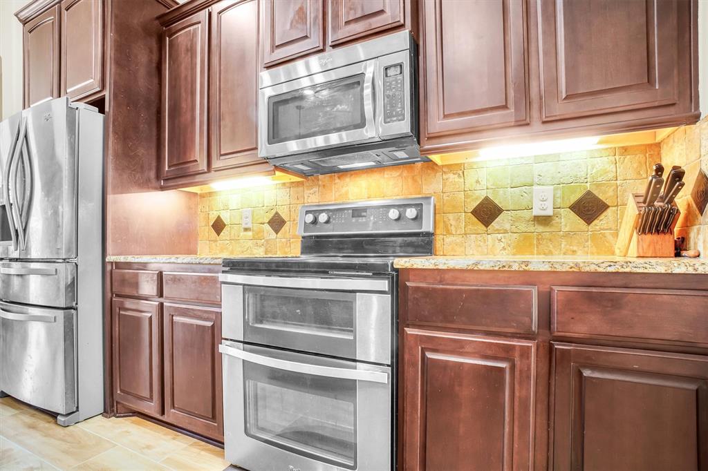 14095 Pecan Lane Forney, TX 75126 - Photo 12 of 40 a kitchen with stainless steel appliances granite countertop a refrigerator stove and sink with granite countertops