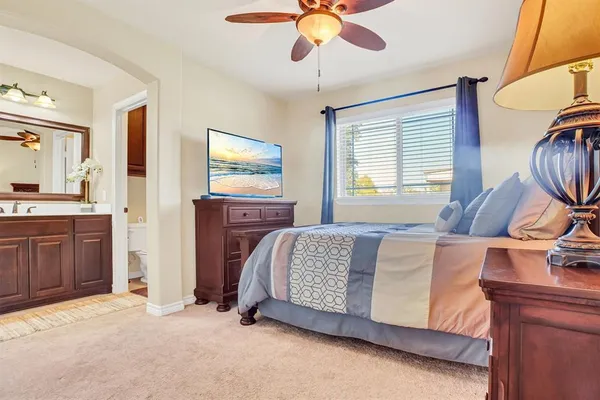 a spacious bedroom with a bed and a chandelier