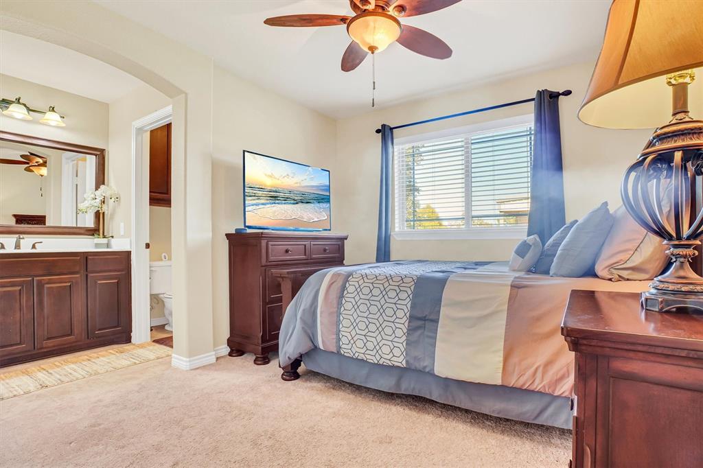 14095 Pecan Lane Forney, TX 75126 - Photo 26 of 40 a spacious bedroom with a bed and a chandelier
