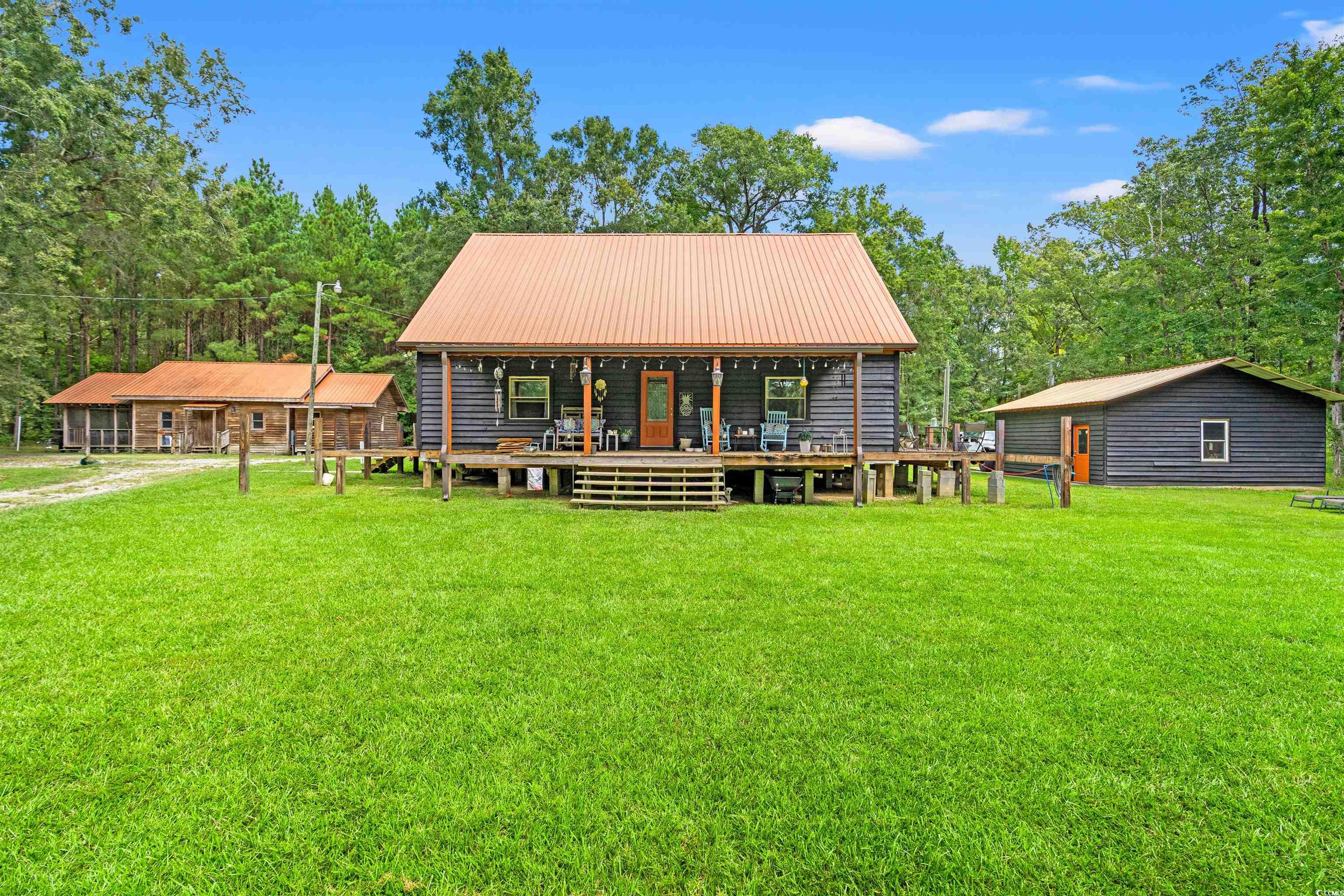 View of front of house with a front yard and a metal roof