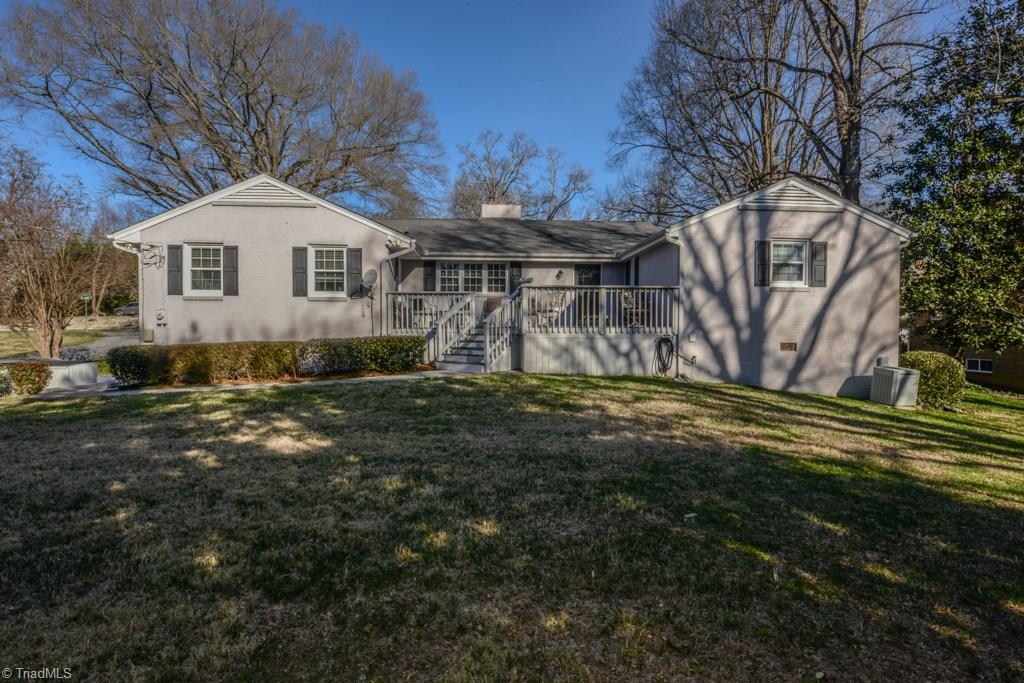 Rear view of home with back deck and flat yard
