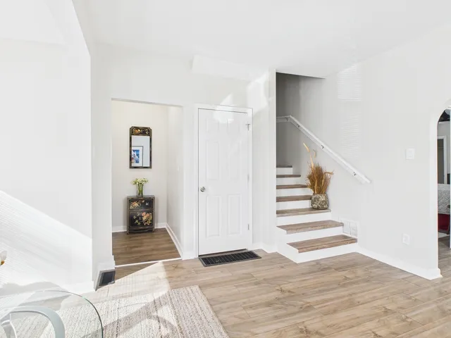 a view of a bedroom with wooden floor and stairs