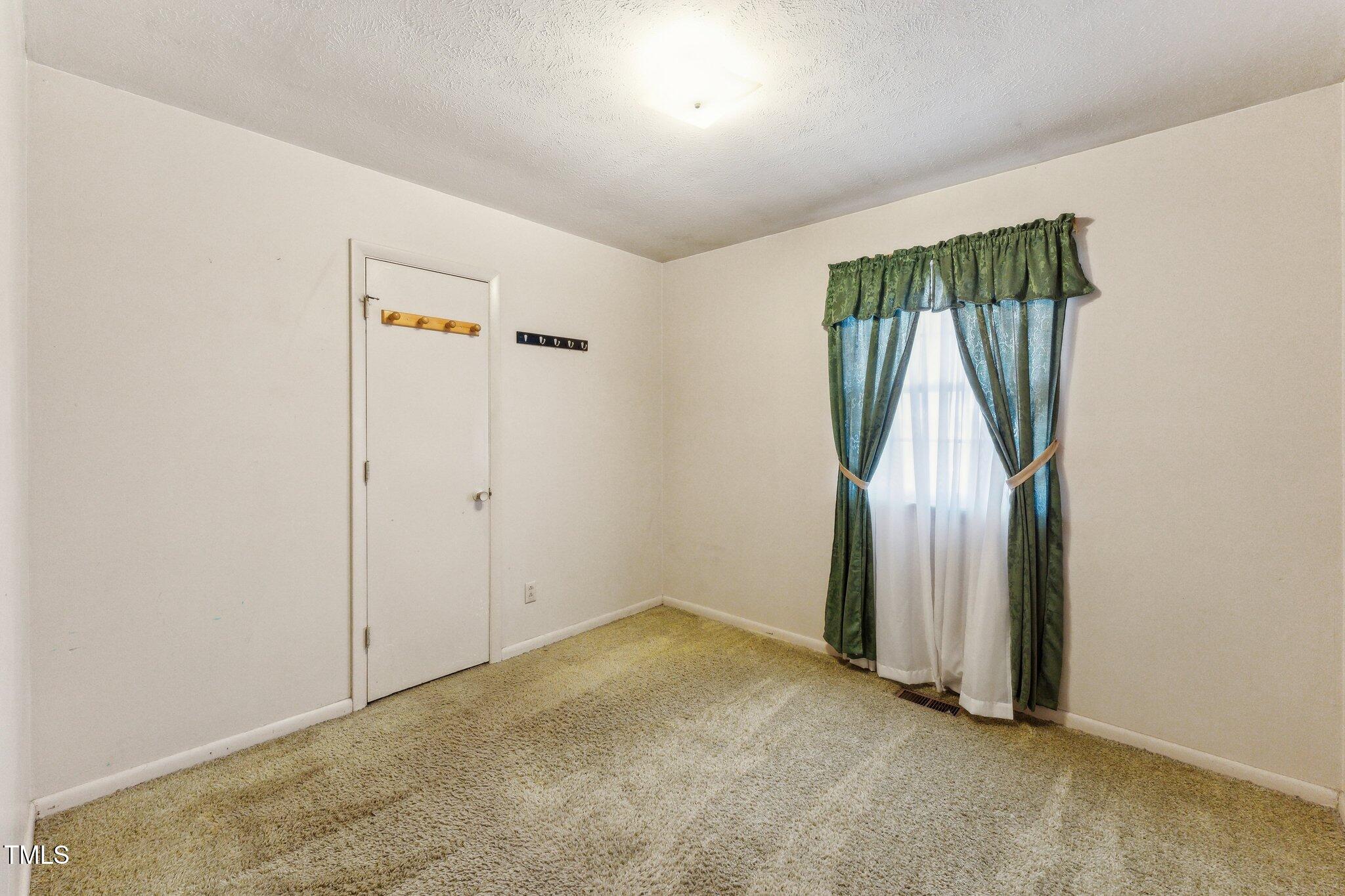 3115 Legion Road Hope Mills, NC 28348 - Photo 19 of 26 an empty room with wooden floor and a window