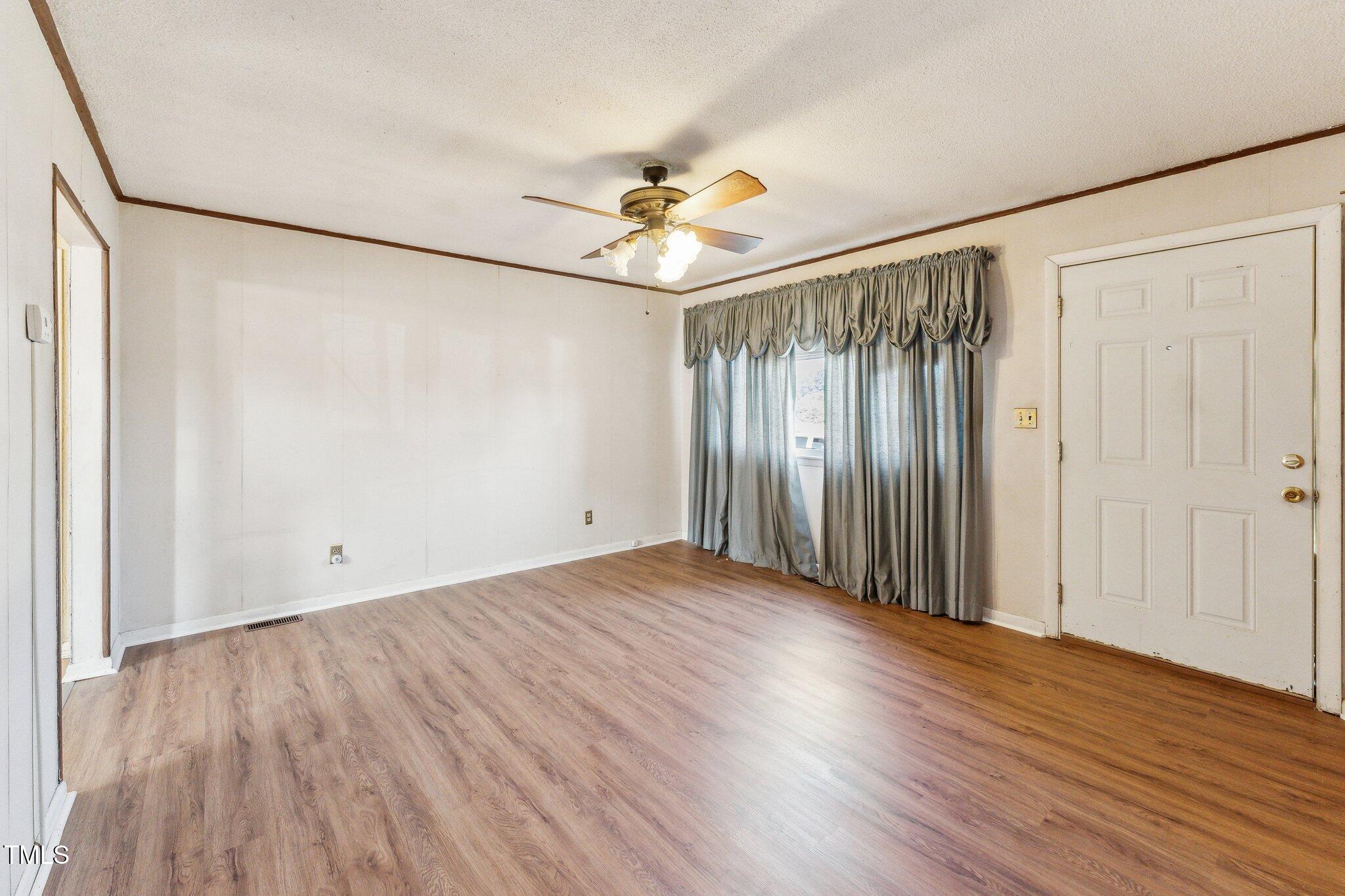 3115 Legion Road Hope Mills, NC 28348 - Photo 4 of 26 an empty room with wooden floor fan and windows