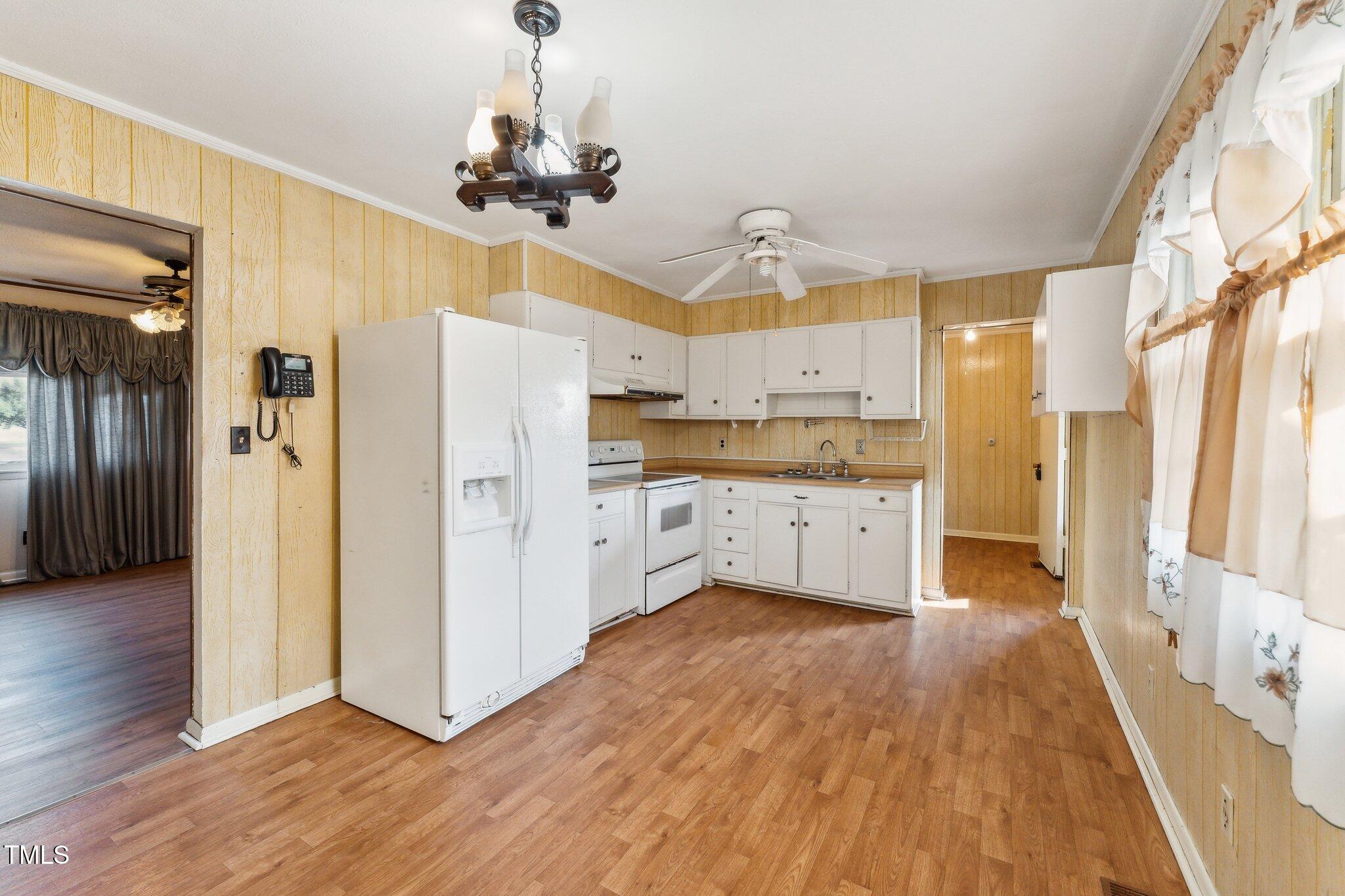 3115 Legion Road Hope Mills, NC 28348 - Photo 7 of 26 a kitchen with wooden floors and refrigerator