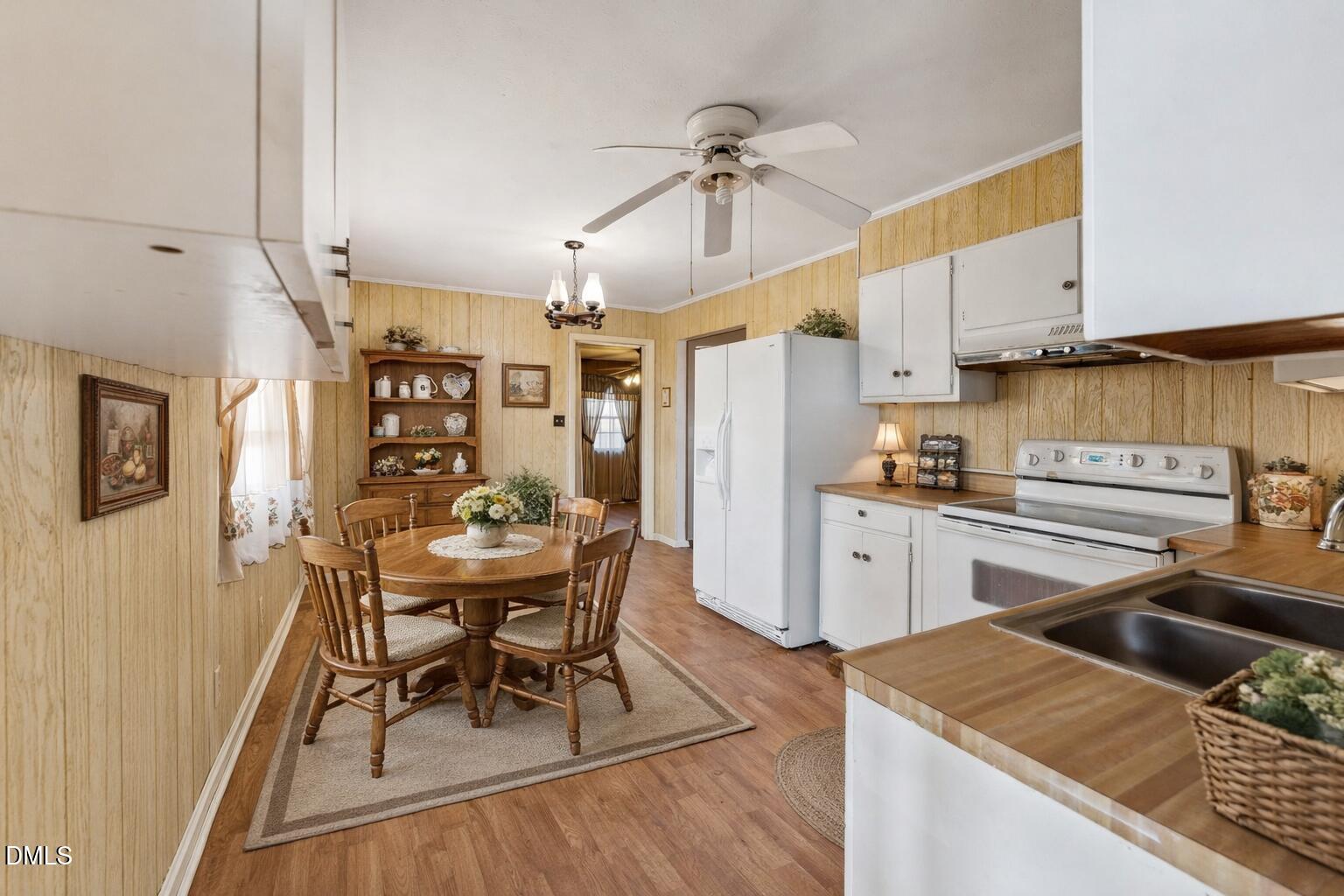3115 Legion Road Hope Mills, NC 28348 - Photo 9 of 26 a kitchen with stainless steel appliances kitchen island granite countertop a table chairs in it and wooden floors