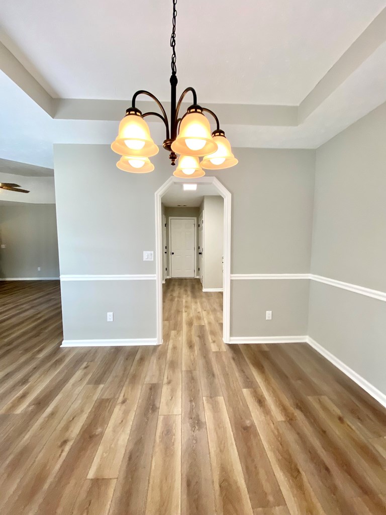 6032 North Pointe Drive Columbus, GA 31909 - Photo 11 of 26 a view of a big room with wooden floor windows and a chandelier