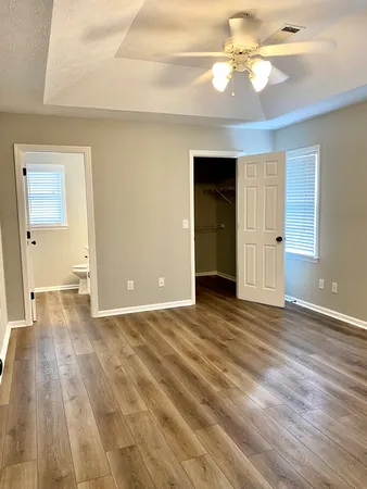 a view of an empty room with window and wooden floor