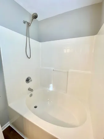 a bathroom with a bath tub with a shower