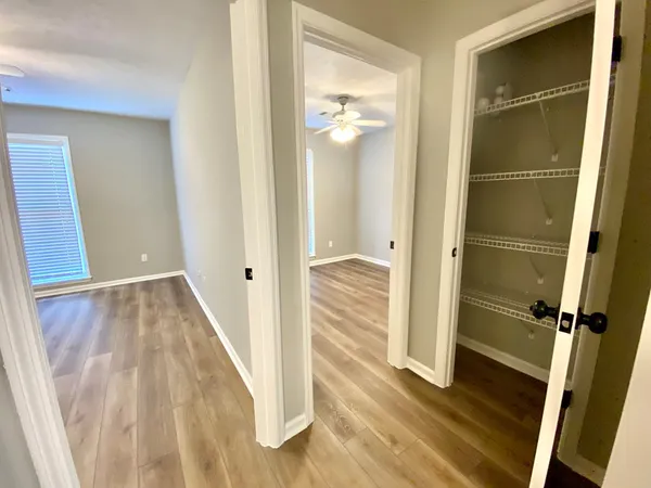 a view of a hallway with wooden floor and staircase