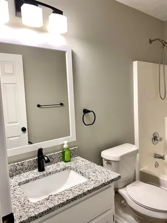 a bathroom with a granite countertop sink and a mirror
