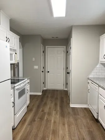 a view of a kitchen with wooden floor and electronic appliances