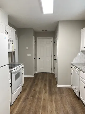 a view of a kitchen with wooden floor and electronic appliances