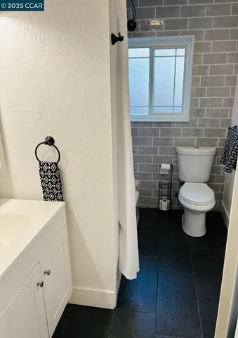 a bathroom with a toilet a sink and mirror