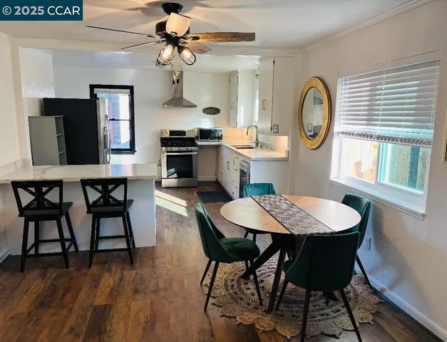 a dining room with wooden floor a chandelier a wooden table and chairs
