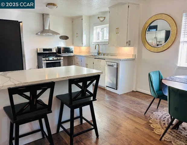 a kitchen with stainless steel appliances a dining table and chairs
