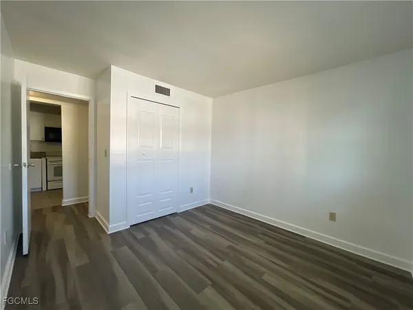 an empty room with wooden floor and closet