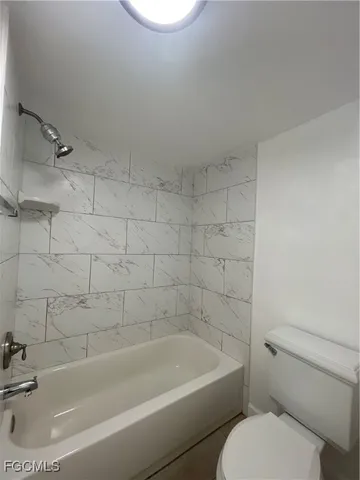 a white bath tub sitting next to a white toilet