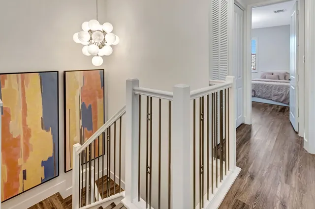 a bedroom with a bed a chair and a chandelier