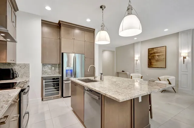 a kitchen with stainless steel appliances kitchen island granite countertop a table and chairs