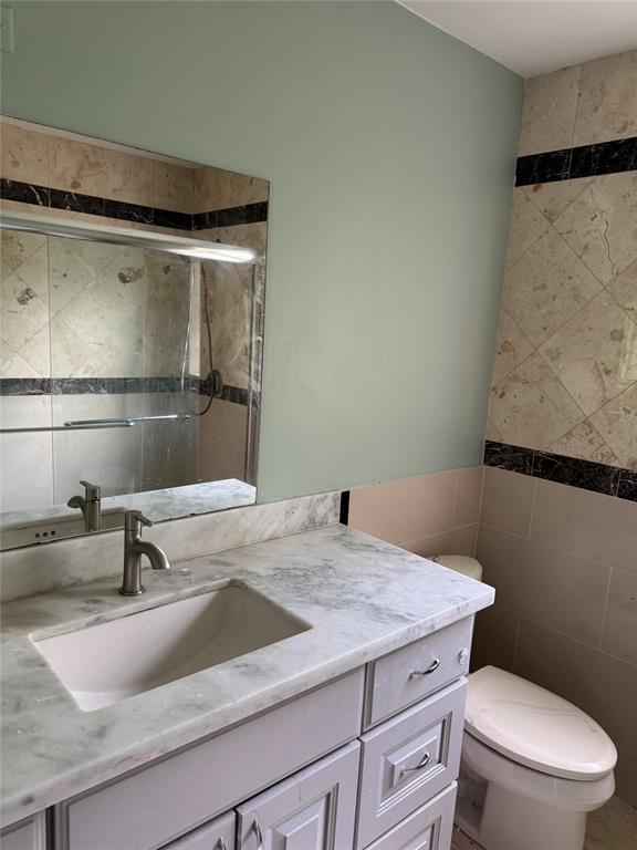 22251 Sands Point Drive Boca Raton, FL 33433 - Photo 21 of 41 a bathroom with a granite countertop sink a toilet and vanity