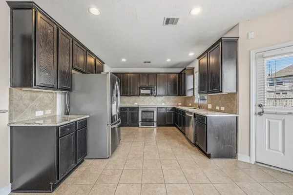 a large kitchen with stainless steel appliances lots of counter top space
