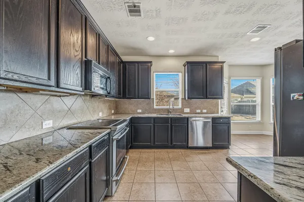 a kitchen with a sink stove top oven and cabinets